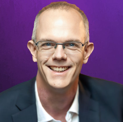 Professional headshot of Lon Welsh, wearing a suit and looking directly at the camera with a fantastic smile